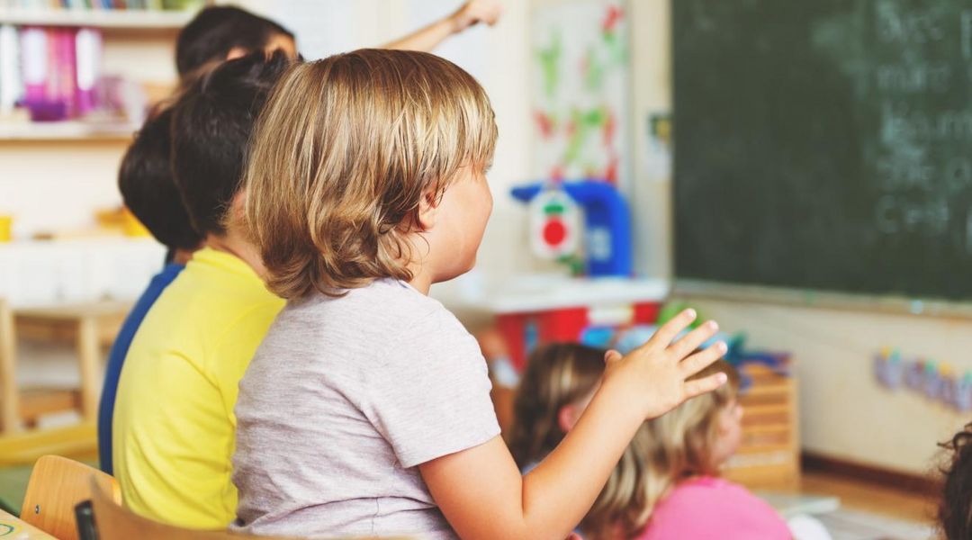 Grundschulkinder im Klassenzimmer beim Folgen des Unterrichts